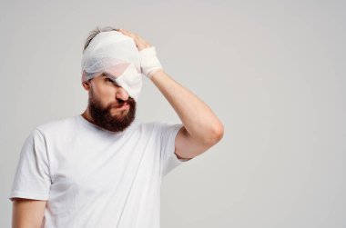 Sakallı adam bandajlı kafa ve göz hastanesi ışık arka planı