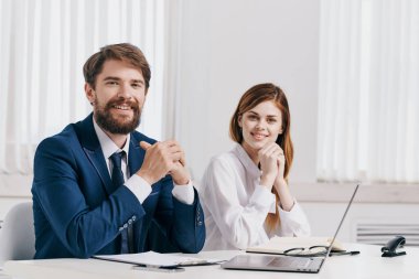 Erkek ve kadın yöneticiler dizüstü bilgisayar profesyonelleri teknolojisinin önünde masada oturuyorlar.