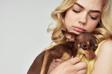 Sarı elbiseli güzel bir kadın. Eğlenceli. Küçük bir köpek manzaralı.