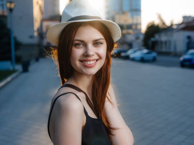 Açık havada poz veren şapkalı çekici bir kadın. Yüksek kalite fotoğraf