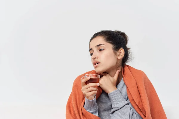 Vrouw bedekt met een deken thuis drinken thee gezondheidsproblemen — Stockfoto