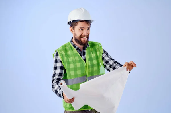 Male builder in a white helmet blueprints Professional blue background — Stock Photo, Image