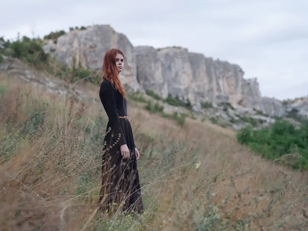 Mulher de vestido preto ao ar livre montanhas andar Estilo de vida liberdade — Fotografia de Stock