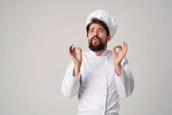 Vousatý muž kuchař uniforma vaření emoce gurmán světlo pozadí — Stock fotografie