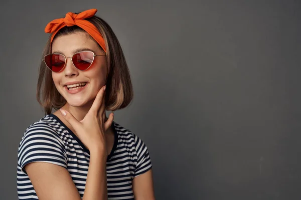 Vrolijk vrouw dragen zonnebril oranje verband op hoofd geïsoleerde achtergrond — Stockfoto