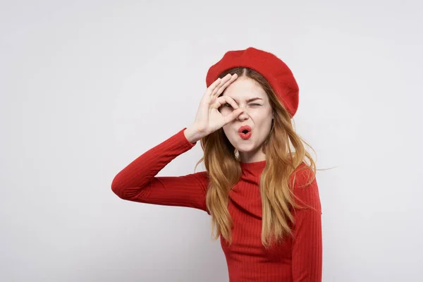 Bonita mulher com um boné vermelho em sua cabeça glamour luz fundo — Fotografia de Stock