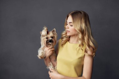 Küçük köpek makyajlı bir kadın. Manzaralı poz veriyor.