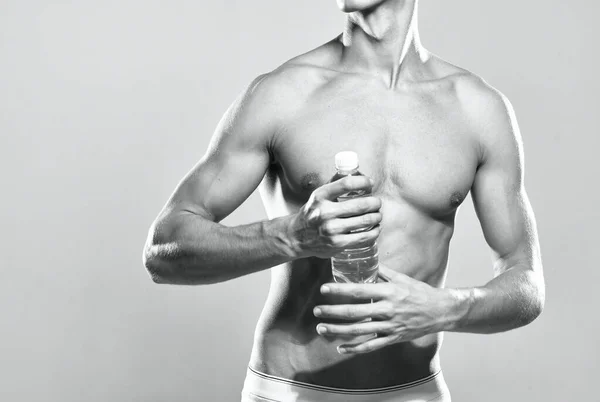 Atletický člověk voda láhev svalnaté tělo studio pózovat — Stock fotografie