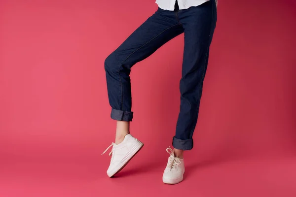 Gambe femminili in sneakers bianche vista a testa in giù rosa sfondo moda — Foto Stock