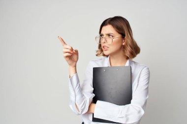 Beyaz gömlekli iş kadını evrakları hafif arka planda çalışıyor