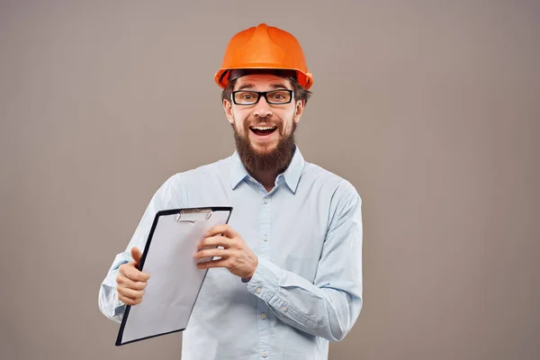 Uomo in arancio hard hat ingegnere progetti lavori di costruzione — Foto Stock