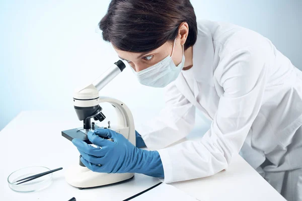 woman laboratory assistant medical mask microscope diagnostics biotechnology