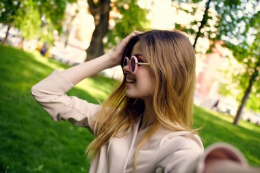 Güzel bir kadın güneş gözlüğü ve parkta yeşil bir şapka.