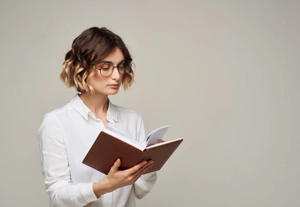 Γυναίκα με γυαλιά με ένα βιβλίο στα χέρια της επίσημη επαγγελματική εργασία — Φωτογραφία Αρχείου
