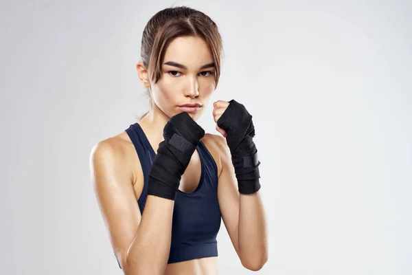 athletic woman boxing punching workout bandages dark background