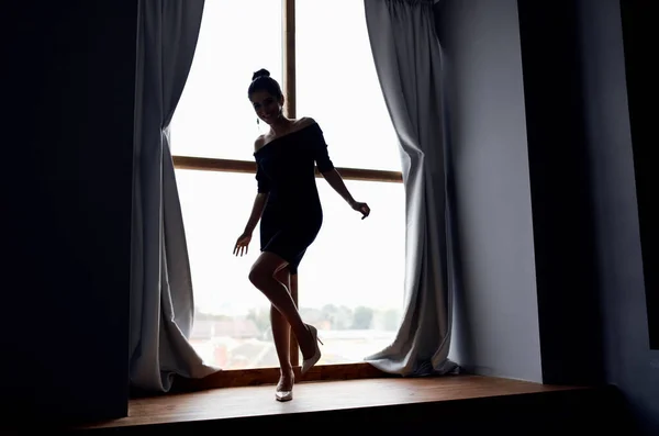 Mujer posando en vestido negro cerca de silueta de ventana modelo —  Fotos de Stock