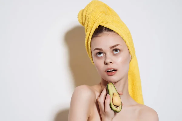Женщина с желтым полотенцем на голове авокадо чистая кожа фрукты диета — стоковое фото