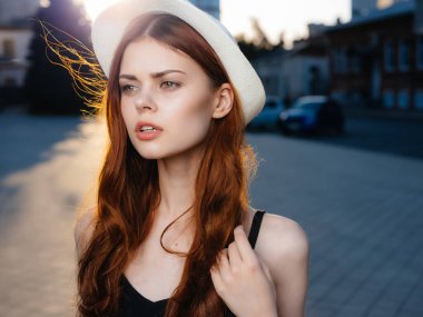 Yazın açık havada poz veren şapkalı güzel bir kadın.