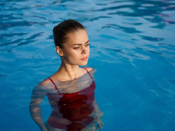 Bonita mujer en un traje de baño Natación en la piscina de lujo naturaleza de ocio —  Fotos de Stock