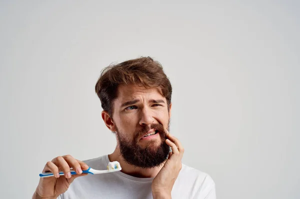 Spazzolino da denti uomo emotivo in mano igiene denti puliti sfondo chiaro — Foto Stock