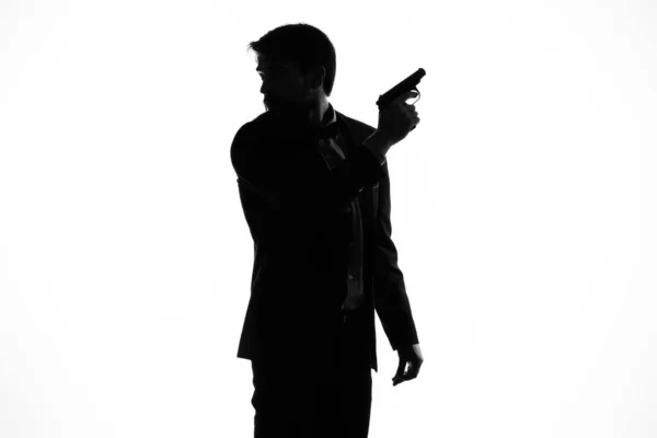 感情のシルエットの光の背景の手にスーツ銃を持った男 — ストック写真