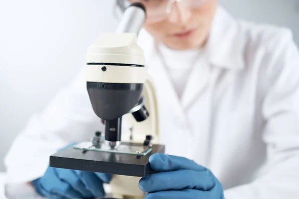Mujer mirando a través de un microscopio solución química laboratorio investigación biotecnología — Foto de Stock