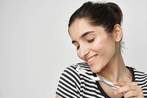 Mulher alegre em uma escova de dentes de t-shirt listrada na mão isolado fundo — Fotografia de Stock