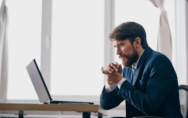 man in suit in front of laptop office manager finance