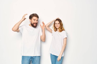 Beyaz tişörtlü ve kotlu genç bir çift günlük moda modelleri giyer.