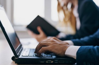 Bir dizüstü bilgisayarın önünde oturan iş arkadaşları internet profesyonelleri