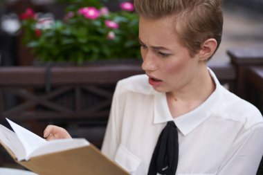 Elinde kitap olan bir öğrenci temiz hava eğitiminde yürüyor.