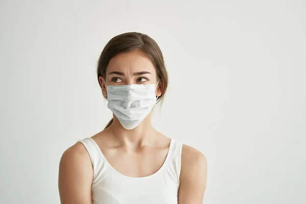 Mujer en máscara médica problemas de salud infección fondo de luz — Foto de Stock