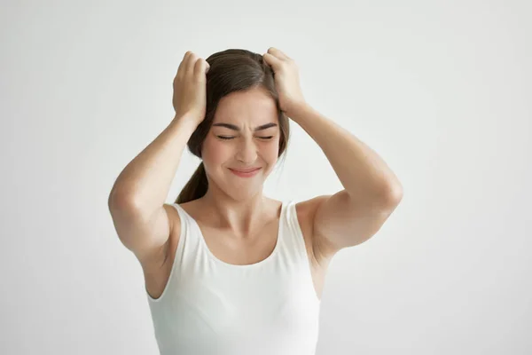 Mujer en camiseta blanca sosteniendo su cabeza dolor de cabeza emociones estilo de vida depresión — Foto de Stock