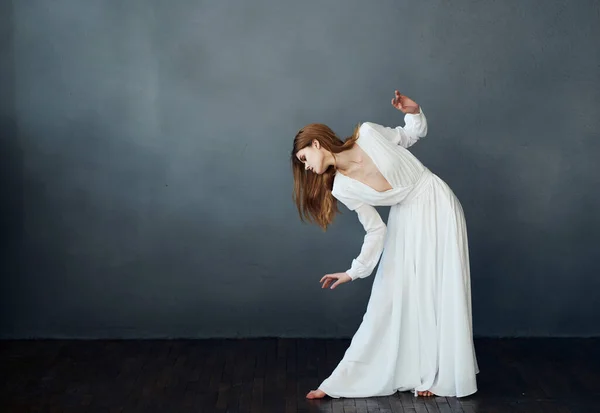 Mulher de vestido branco movimento de dança realizando fundo escuro — Fotografia de Stock
