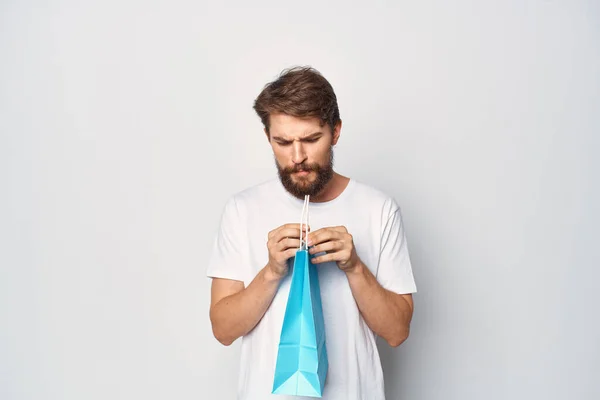 Чоловік у білій футболці з синім пакетом моди продаж світлого фону — стокове фото