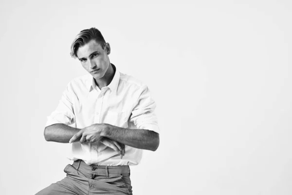 Beyaz gömlekli ve pantolonlu yakışıklı adam stüdyo tarzı modern poz veriyor. — Stok fotoğraf