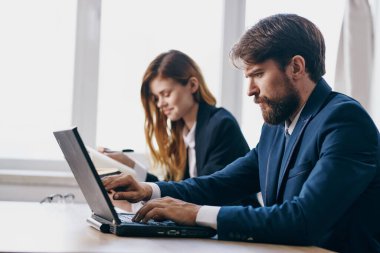 Bir dizüstü bilgisayarın önünde oturan yöneticiler internet profesyonelleri