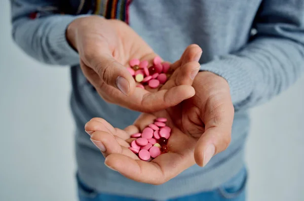 Skäggig man i en tröja med piller i handen hälsoproblem isolerad bakgrund — Stockfoto