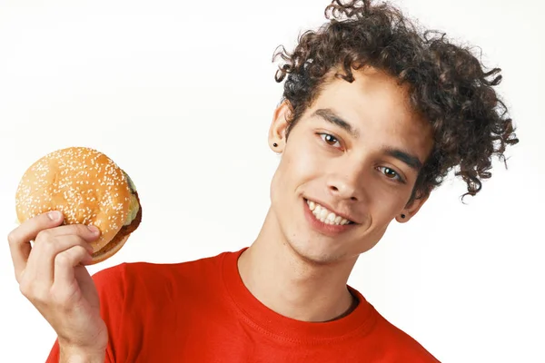 Hambúrguer encaracolado alegre cara segurando um estilo de vida t-shirt vermelha — Fotografia de Stock