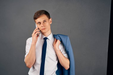 Gömlekli, kravatlı bir adam telefonda profesyonel iş ofisinde konuşuyor.