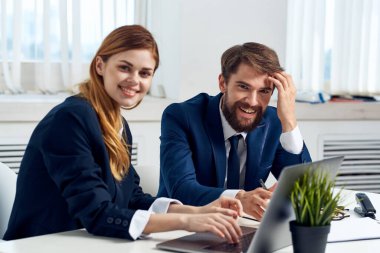 Meslektaşlar dizüstü bilgisayar teknolojisinin önünde konuşuyor.