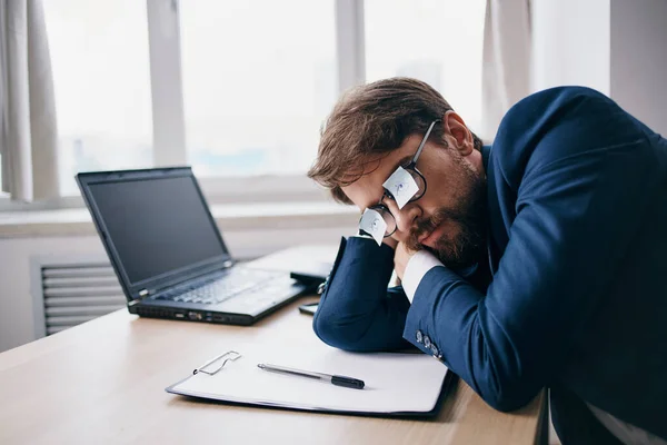 Homem sentado em uma mesa na frente de um oficial da rede de finanças laptop — Fotografia de Stock