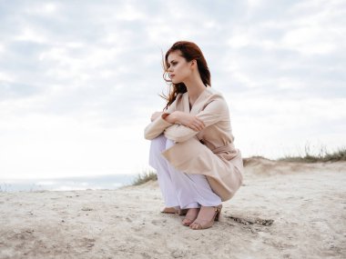 Kum modelinde oturan güzel kadın Seyahat et