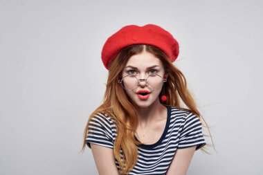 Çizgili tişörtlü neşeli kadın. Kırmızı dudaklar. Elleriyle temiz hava.