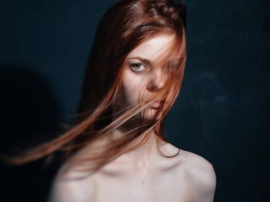 Çıplak omuzlu bir kadın. Kızıl saçlı.