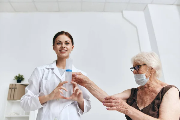 En äldre kvinna vid läkarbesök en injektion i immunitetsskyddet i armen — Stockfoto