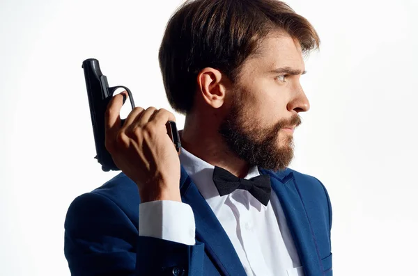 Mann im Anzug mit Pistole in der Hand heller Hintergrund — Stockfoto