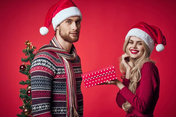 Junges Paar Weihnachtsdekoration Urlaub posiert roten Hintergrund — Stockfoto