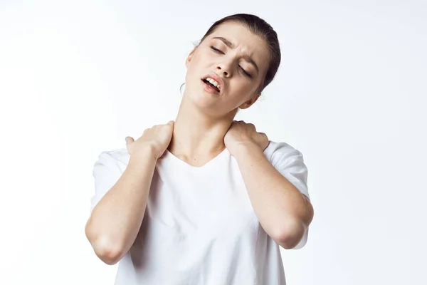 Žena v bílém tričku drží ramena bolest šíje zdravotní problémy nepohodlí — Stock fotografie