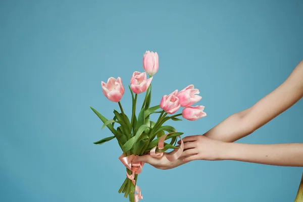 Букет квітів в руках романтика подарунок синій фон — стокове фото